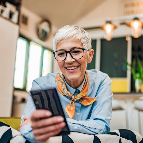 Une femme à l'intérieur regarde son téléphone portable.