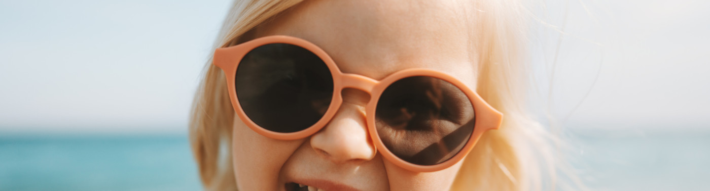 Une petite fille portant des lunettes de soleil tire la langue.